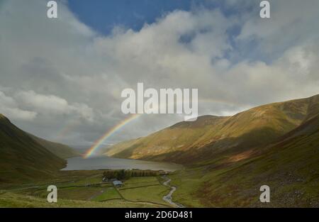 Arcobaleno vivido attraverso il bacino idrico di Talla in autunno, confini scozzesi. Foto Stock