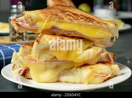 sandwich di prosciutto e formaggio alla griglia impilati su un piatto Foto Stock