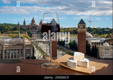 Bicchiere di vino rosso con formaggio brie con vista su Piazza Spagna a Barcellona, Spagna Foto Stock