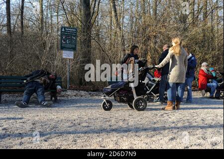 20.03.2015, Monaco di Baviera, Baviera, Germania - genitori e bambini visitano un parco giochi pubblico presso la Torre Cinese nel Giardino Inglese su di una collina soleggiata Foto Stock