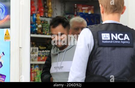 VOLTI PIXELATED DA PA PICTURE DESK SU RICHIESTA DI AGENZIA NAZIONALE DI CRIMINALITÀ UN uomo è arrestato da ufficiali durante un'operazione di Agenzia nazionale del crimine (NCA) in Hastings, Sussex orientale, collegato con le indagini sugli incroci migranti. Foto Stock