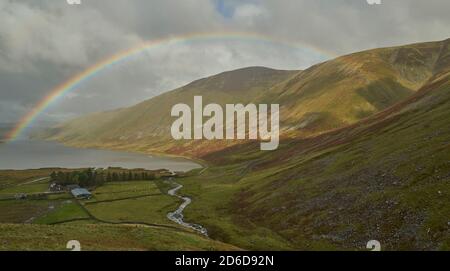 Arcobaleno vivido attraverso il bacino idrico di Talla in autunno, confini scozzesi. Foto Stock