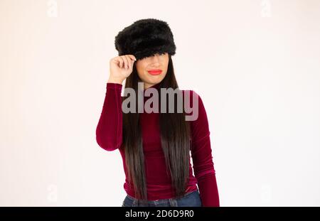 Offerta invernale brillante, offerta. Ragazza spensierata che copre un occhio con cappello nero, copia spazio Foto Stock