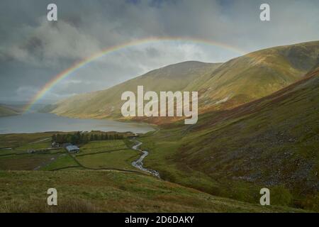 Arcobaleno vivido attraverso il bacino idrico di Talla in autunno, confini scozzesi. Foto Stock