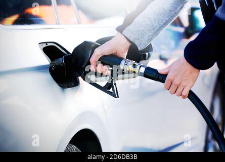 Uomo che pompa benzina alla stazione di servizio. Impianto di rifornimento del veicolo presso il distributore di benzina. Il prezzo della benzina scende dopo la pandemia del coronavirus. Foto Stock