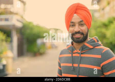 Giovane bell'uomo indiano Sikh che indossa il turbante per le strade all'aperto Foto Stock