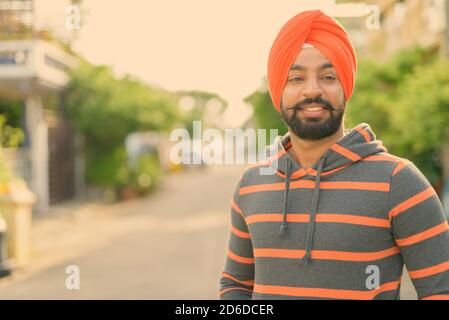 Giovane bell'uomo indiano Sikh che indossa il turbante per le strade all'aperto Foto Stock