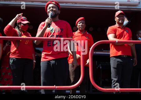 Il leader del FEP Julius Malema e i membri dell'Economic Freedom Fighters (EFF) cantano slogan fuori dalla corte dei magistrati durante la protesta. UN confronto teso tra agricoltori bianchi e attivisti neri ha afferrato la città sudafricana di Senekal, come due uomini accusati di aver ucciso un manager bianco fattoria dovevano comparire in tribunale. Più di 100 poliziotti hanno pattugliato l'area di fronte al tribunale della provincia dello Stato libero e hanno utilizzato il filo spinato per separare i gruppi rivali. Foto Stock