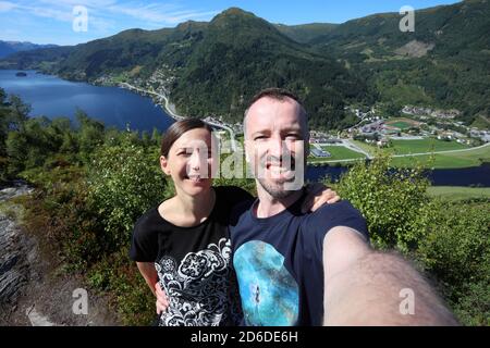 Coppia viaggiatore selfie in Norvegia zona escursionistica - sentiero di montagna sopra la città di Naustdal (comune Sunnfjord). Attività ricreative all'aperto. Foto Stock