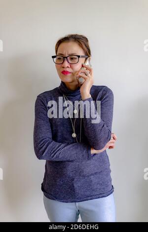 Arrabbiato donna asiatica d'affari che parla sul telefono cellulare. Isolato su bianco. Foto Stock