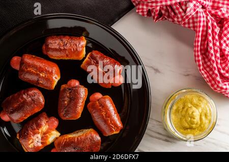 Mini pretzel hot dog maiali in una coperta con senape digione per l'immersione Foto Stock