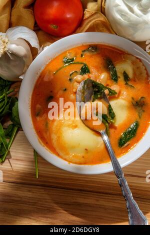 Crema di ravioli al formaggio italiano con fagioli cannellini e spinaci Foto Stock