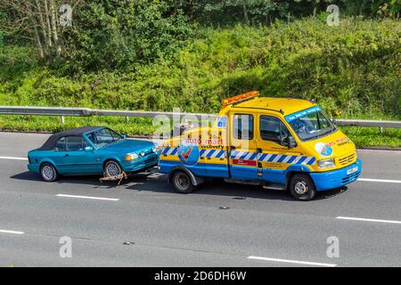 2001 blu giallo Renault Mascott Auto Mart veicolo di traino servizio 24h operatori di recupero; camion di consegna di trasporto, camion rimorchio, trasporto, camion di soccorso di emergenza, vettore auto, veicolo Ford, trasporto commerciale europeo, industria, M61 a Manchester, Regno Unito Foto Stock