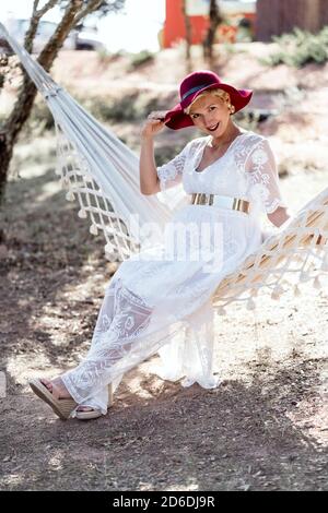 Elegante donna incinta riposante su amaca all'aperto Foto Stock