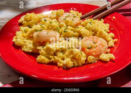 Cucina cinese gamberetti fritti uova strapazzate guarnite con erba cipollina Foto Stock