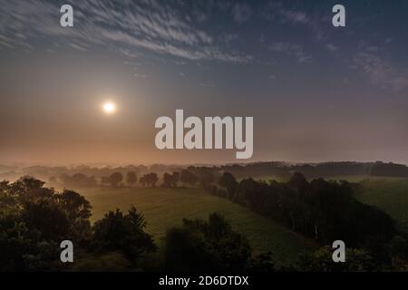 Luna sorge su Wietmarschen vicino a Nordhorn con luce nebbia a terra Foto Stock