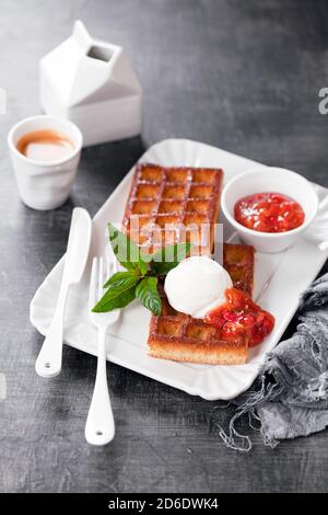 Waffle fatti in casa con farina di mandorle, gelato al cocco e marmellata di fragole al limone, fuoco selettivo Foto Stock