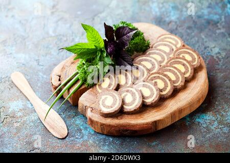 Pate di rotolo di fegato fatto in casa con burro su tagliere di legno, fuoco selettivo Foto Stock