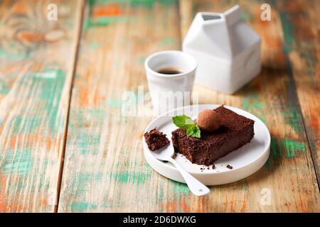 Brownie fatte in casa in stile paleo senza glutine preparate con patate dolci o zucca e farina di cocco decorata con tartufo al cioccolato, fuoco selettivo Foto Stock