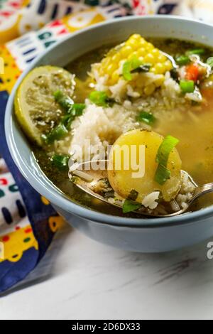 Coriandolo peruviana la zuppa di pollo o Aguadito de Pollo con yukon gold patate sulla pannocchia di mais e la calce e slice Foto Stock