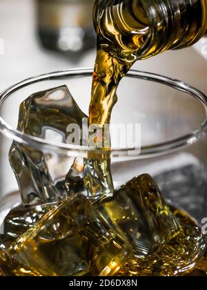 Immagine ravvicinata del whisky versato da una bottiglia un bicchiere Foto Stock