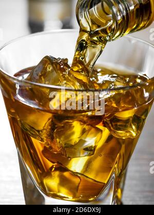 Immagine ravvicinata del whisky versato da una bottiglia un bicchiere Foto Stock
