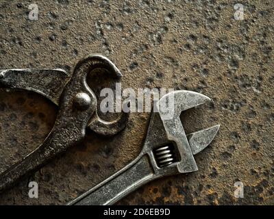 Chiave e pinza su fondo di metallo arrugginito Foto Stock