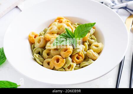 Ravioli italiani con spinaci e ricotta in piatto bianco. Tortellini italiani. Foto Stock