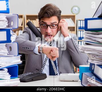 Il businessman occupato sotto stress a causa di un eccessivo lavoro Foto Stock