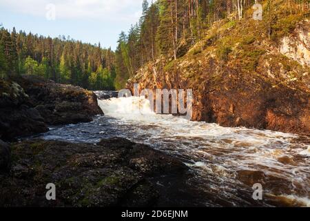 Parco nazionale di Oulanka. Cascata delle rapide di Kiutaköngäs con parete di roccia calcarea rossa durante un'alba estiva nella natura finlandese, nel Nord Europa. Foto Stock