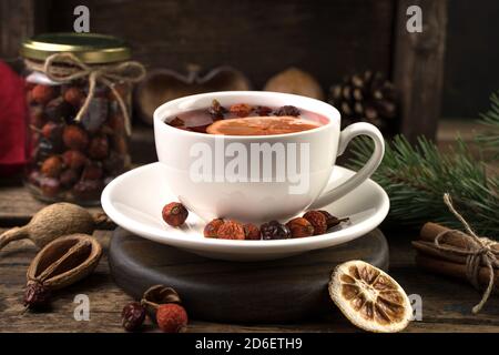 Tè con cannella e limone in una tazza bianca da vicino - su uno sfondo scuro. Foto Stock