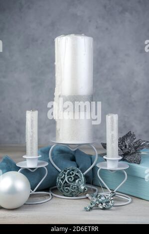 Confezione regalo, giocattoli natalizi e candele su sfondo grigio. Foto Stock