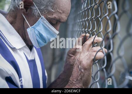 LA VEGA REPUBBLICA DOMINICANA, REPUBBLICA DOMINICANA - 14 Ott 2020: Un uomo latino o ispanico di 70-80 anni con maschera facciale crestfall contro un metallo Foto Stock