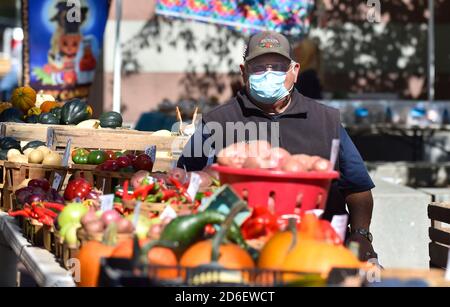 Wilkes-barre, Pennsylvania, Stati Uniti. 15 Ott 2020. Un venditore che indossa una maschera facciale come misura preventiva attende i clienti al Farmers Market.Every Giovedi c'è un mercato agricolo pubblico in Piazza pubblica a Wilkes-barre dove la maggior parte degli acquirenti e agricoltori si conformano con la maschera indossare. Credit: Aimee Dilger/SOPA Images/ZUMA Wire/Alamy Live News Foto Stock