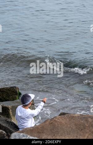 Germania, Meclemburgo-Pomerania occidentale, Sassnitz, ragazzo getta pietre nel Mar Baltico Foto Stock