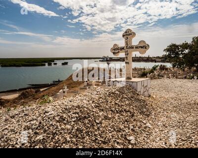 Joal-Fadiouth, Afrika - Jan, 2019: Croce cattolica su una tomba in un cimitero misto musulmano-cristiano. La città e il comune di Joal-Fadiouth nel Thi Foto Stock