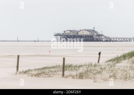 Ampie, un sacco di sabbia e palafitte sulla spiaggia di San Pietro Ording, Wadden Mare, Mare del Nord Foto Stock