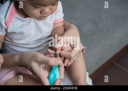 primo piano di un ragazzino tranquillo che taglia le unghie per renderlo pulito e sano Foto Stock