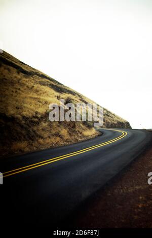 Autostrada curva a due corsie che sale su Hillside Foto Stock