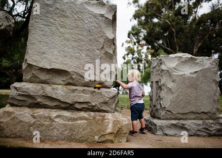 Due anni in piedi tra le pietre di testa al parco Foto Stock