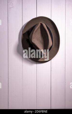 un vecchio cappello appeso su un muro di legno bianco Foto Stock