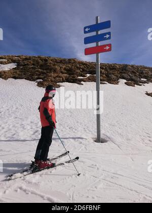 Sciatore guardando un segno sul livello di difficoltà delle piste in una stazione sciistica. Concetto di sci Foto Stock