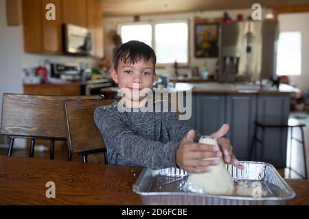 Ragazzo di primo grado che costruisce il vulcano in homeschool Foto Stock