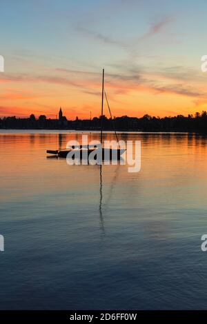 Barca a vela al tramonto sul Chiemsee, Riemsting, alta Baviera, Germania Foto Stock
