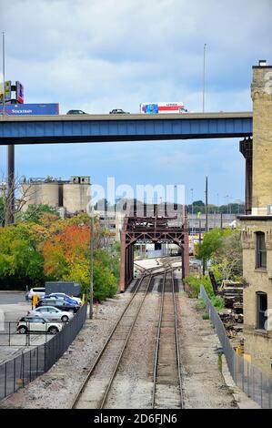 Milwaukee, Wisconsin, Stati Uniti. I binari della Canadian Pacific Railway si uniscono attraverso magazzini che conducono attraverso un ponte sul fiume Menomonee. Foto Stock