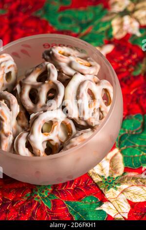 Pretzel di cioccolato bianco in ciotola sul runner del tavolo di Natale Foto Stock