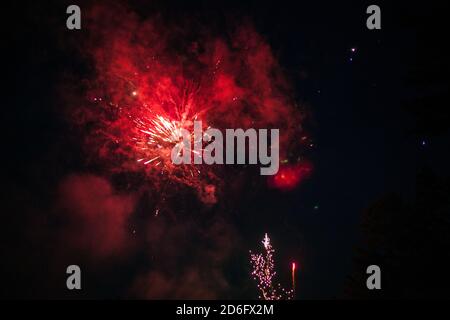 Fuochi d'artificio rossi nel cielo stellato notturno Foto Stock