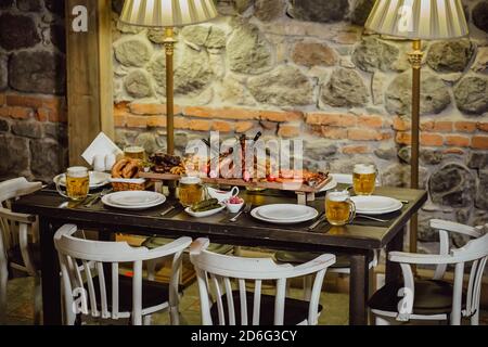 Il ristorante serve un tavolo con diversi piatti. Interno del vecchio ristorante con tavolo fisso. Foto Stock