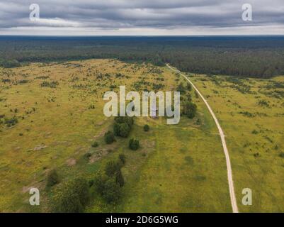 Agosto, 2020 - Lag rosso. Abbandonata alta chiesa in legno nel mezzo di un grande campo. Russia, regione di Arkhangelsk Foto Stock