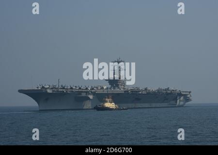 201007-A-FT904-1054 GOLFO DEL BAHRAIN (OTTOBRE 7, 2020) UN rimorchiatore Bahraini si stira lungo la portaerei USS Nimitz (CVN 68) attraverso il Golfo del Bahrain, incomiando ad una visita di manutenzione e logistica al porto Khalifa bin Salman, Bahrain, 7 ottobre. Nimitz, il fiore all'occhiello del Nimitz Carrier Strike Group, è schierato nell'area operativa della 5a flotta degli Stati Uniti, conducendo missioni a sostegno dell'OIR, e operazioni di sicurezza marittima a fianco di partner regionali e di coalizione. (STATI UNITI Esercito foto di staff Sgt. Timoteo Clegg Foto Stock